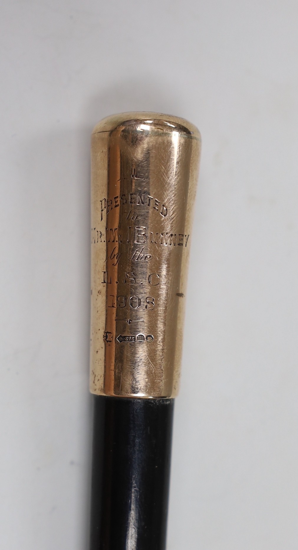 An Edwardian 9ct gold mounted ebonised baton, with presentation inscription to Mr. W.J. Bunny', maker Charles Edwards, London, 1908, 49.4cm.